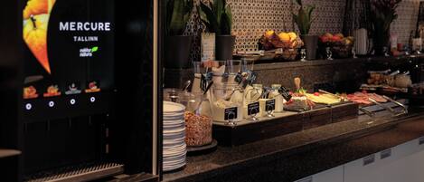 A breakfast buffet with various food items and a coffee machine.