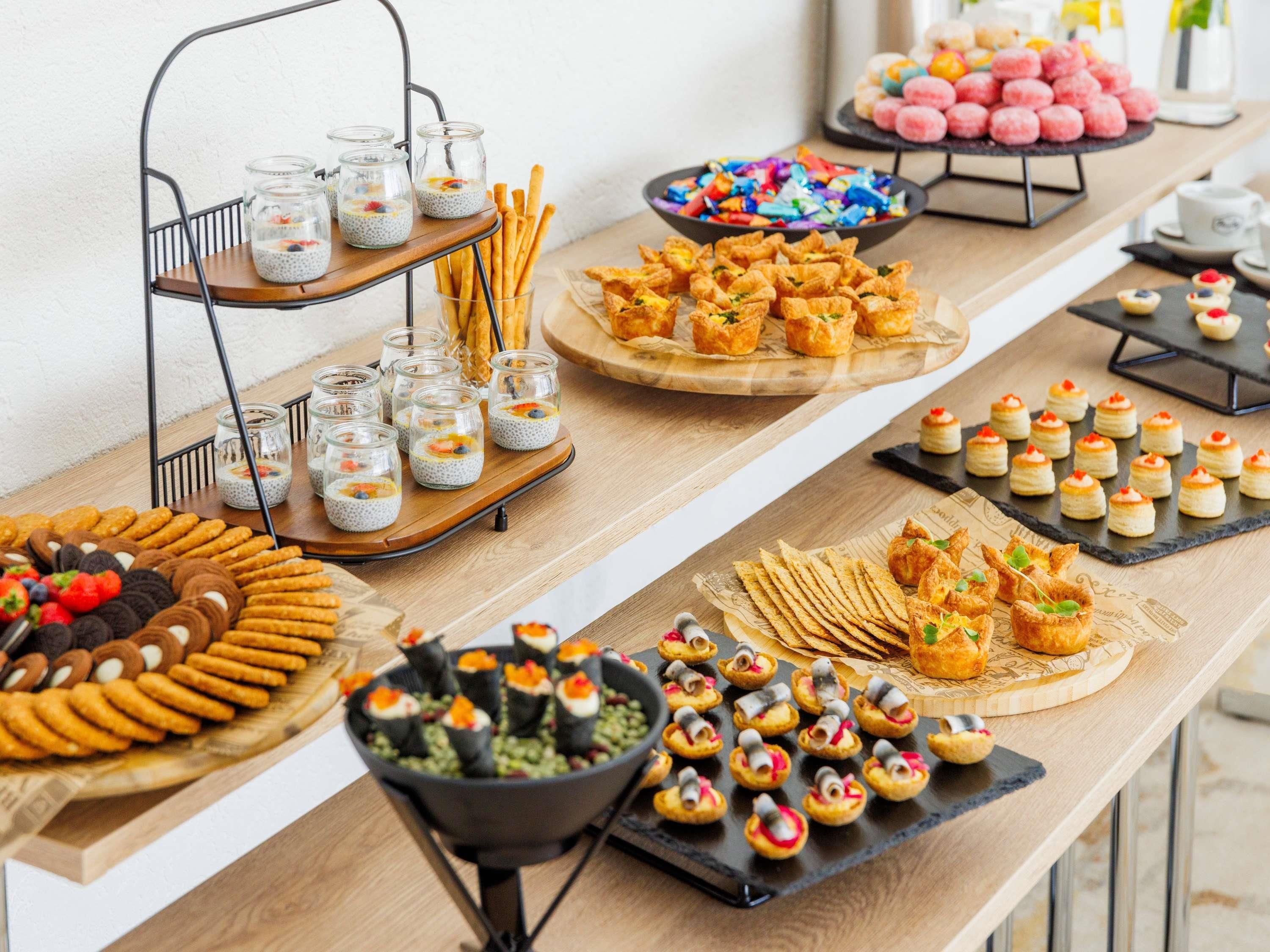 A buffet with various food items including jars of chia pudding, cookies, and pastries.