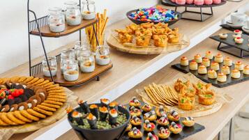 A buffet with various food items including jars of chia pudding, cookies, and pastries.