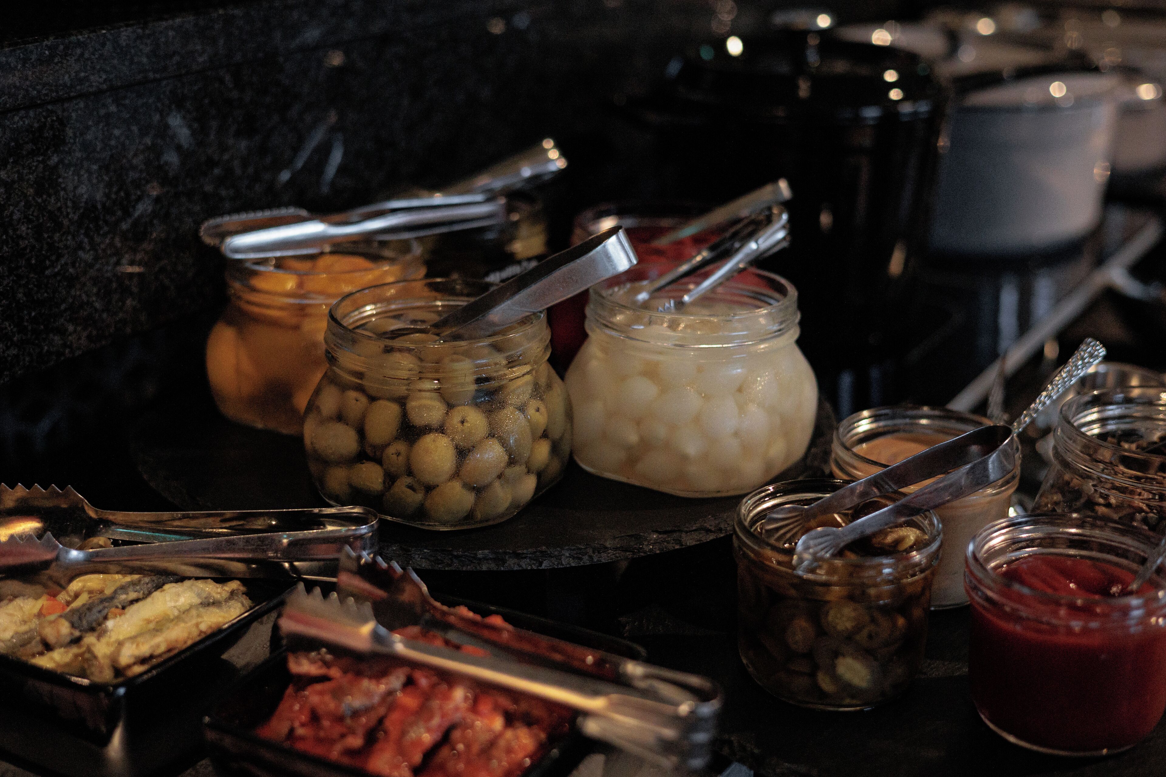 Una mesa de buffet con diversos alimentos y salsas.