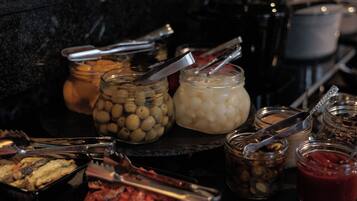 Una mesa de buffet con diversos alimentos y salsas.