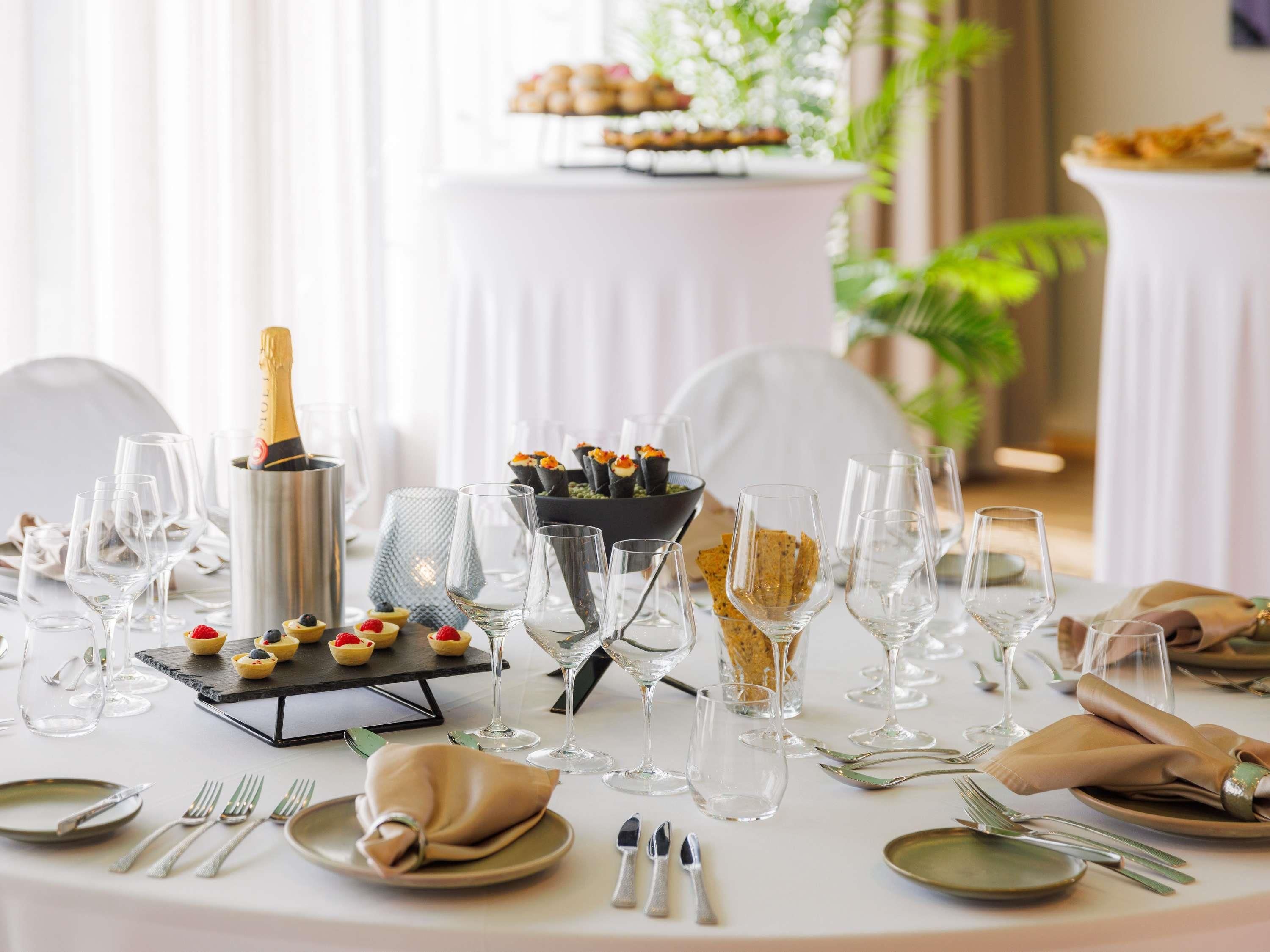 Ett elegant dukat matbord med vinglas, champagne och aptitretare.
