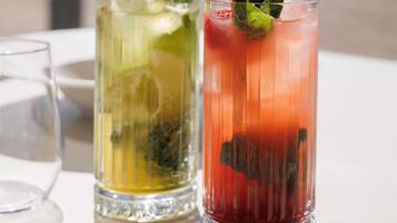 Two glasses of beverages on a table.