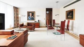 Ein modernes Wohnzimmer mit Sofa, Couchtisch und Essbereich mit Stühlen und einem Glastisch.