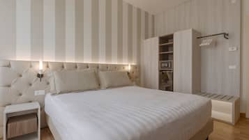 A bedroom with a large bed, a nightstand, a wardrobe, and a wall-mounted light fixture.