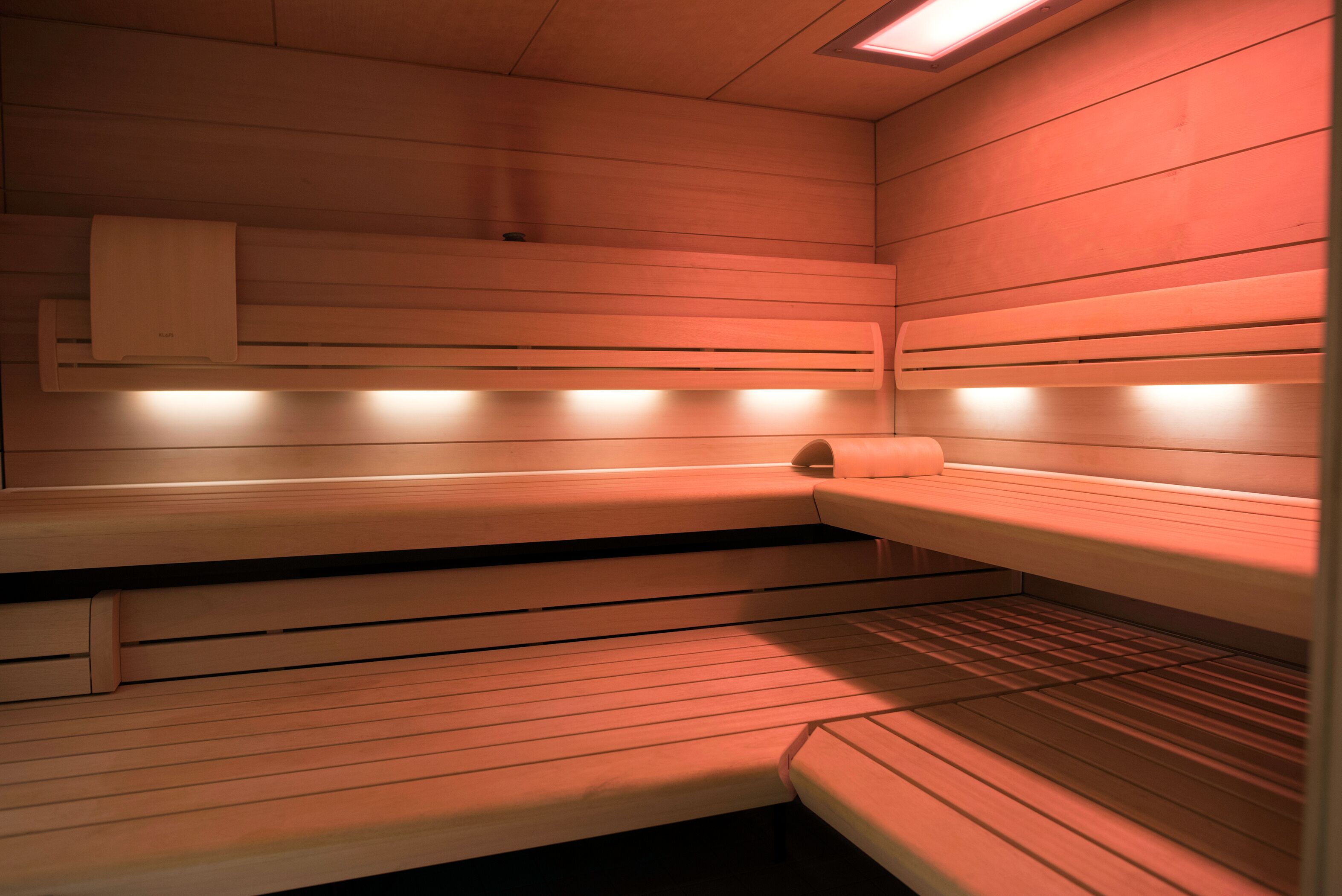 Eine Sauna mit Holzbänken und einer Sitzbank.