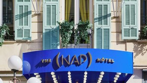 The entrance to The (NAP) Hotel with a blue facade, decorative lighting, and potted plants. - Hotel Nap By HappyCulture (Nice)