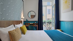 A hotel room with a bed, a desk, a chair, a round mirror, and a view of the outside balcony. - Hotel Nap By HappyCulture (Nice)