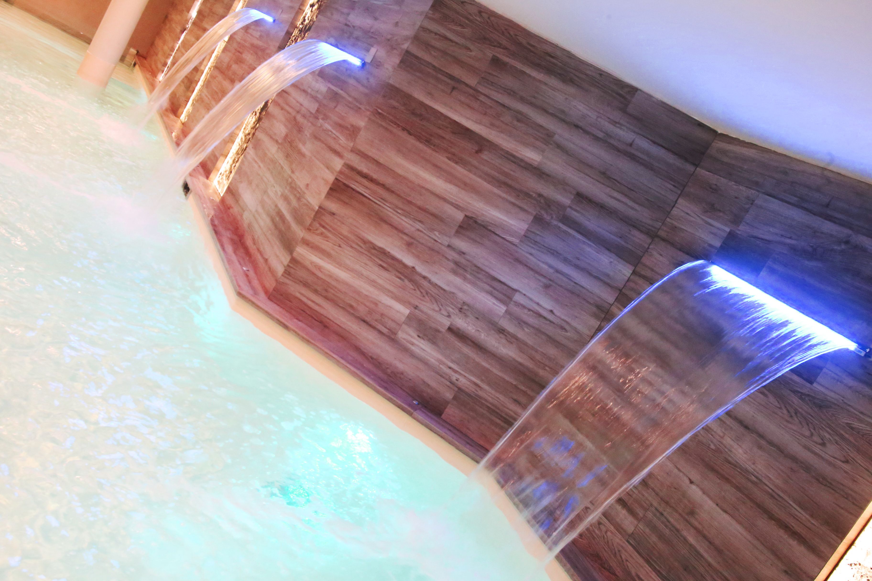 A spa area with a wooden wall and a water feature.