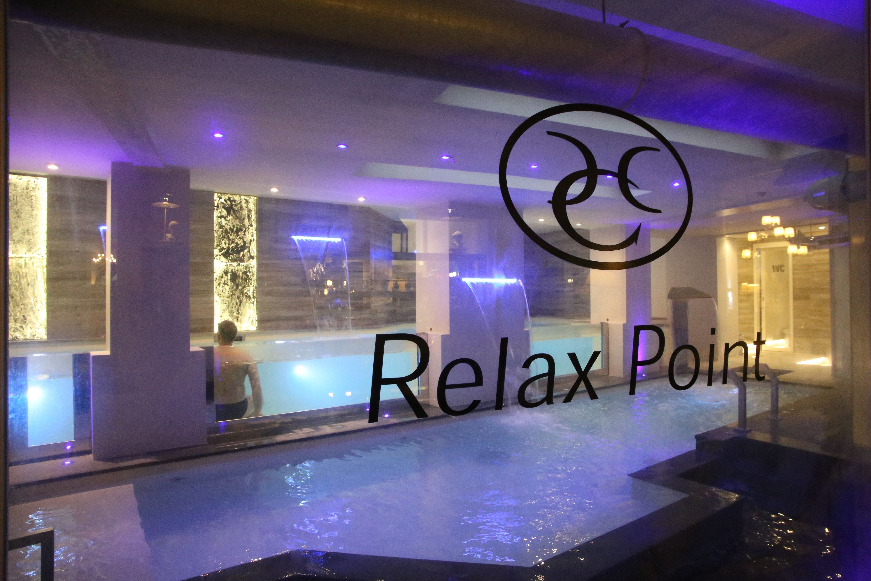 A spa area with a hot tub and a person relaxing.
