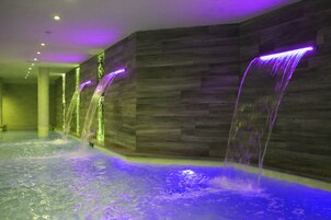 Zona de spa con fuente de agua y paredes de madera.