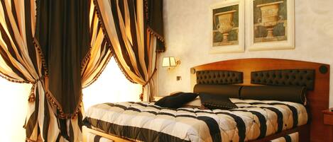 A bedroom with a large bed, a wooden headboard, and two wall-mounted lamps.
