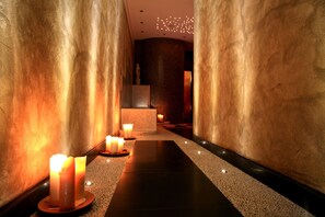 A corridor with candles, a statue, and a textured wall. - Hotel Columbia Wellness SPA (Montecatini Terme)