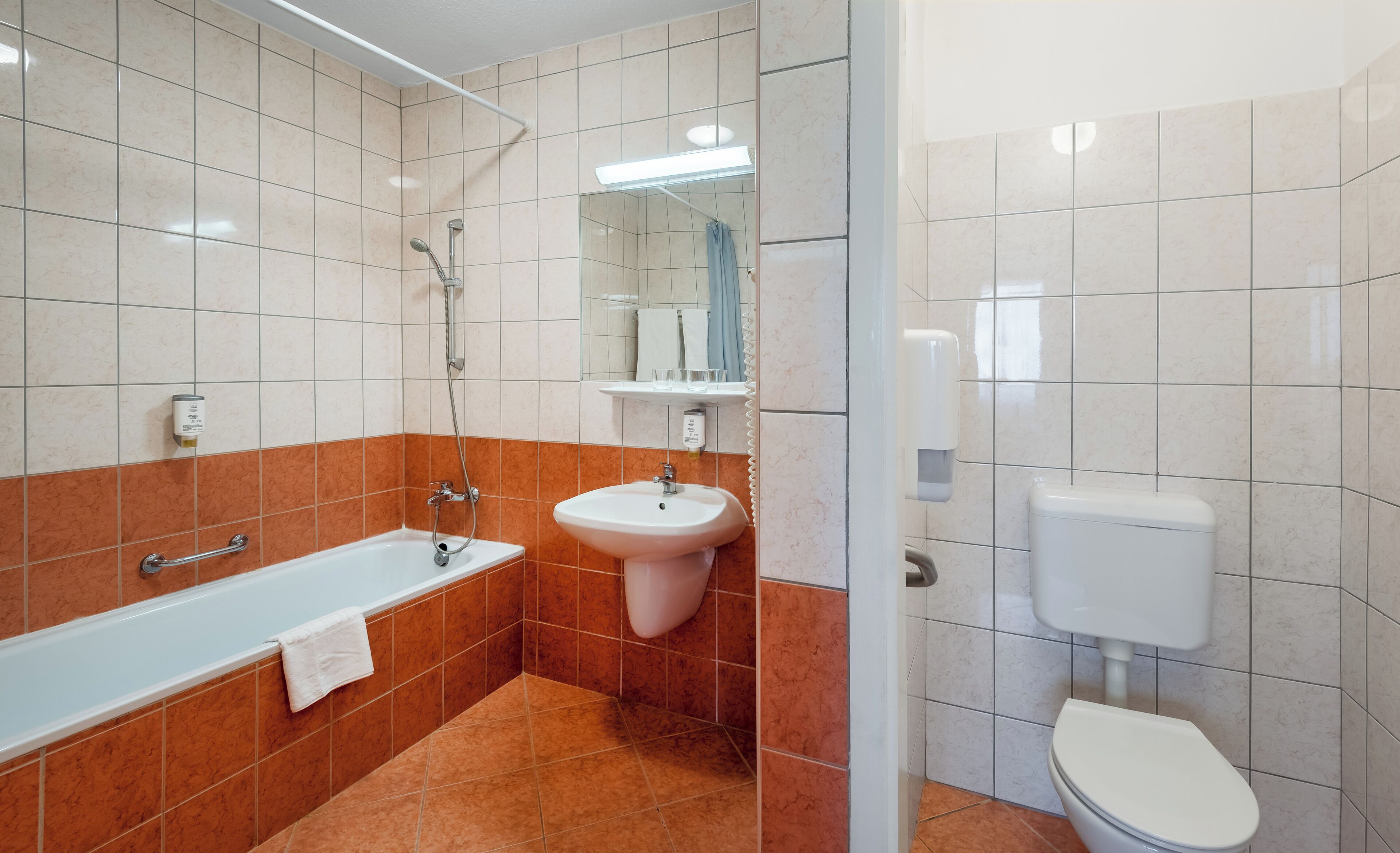 A modern bathroom with a bathtub, sink, and toilet.