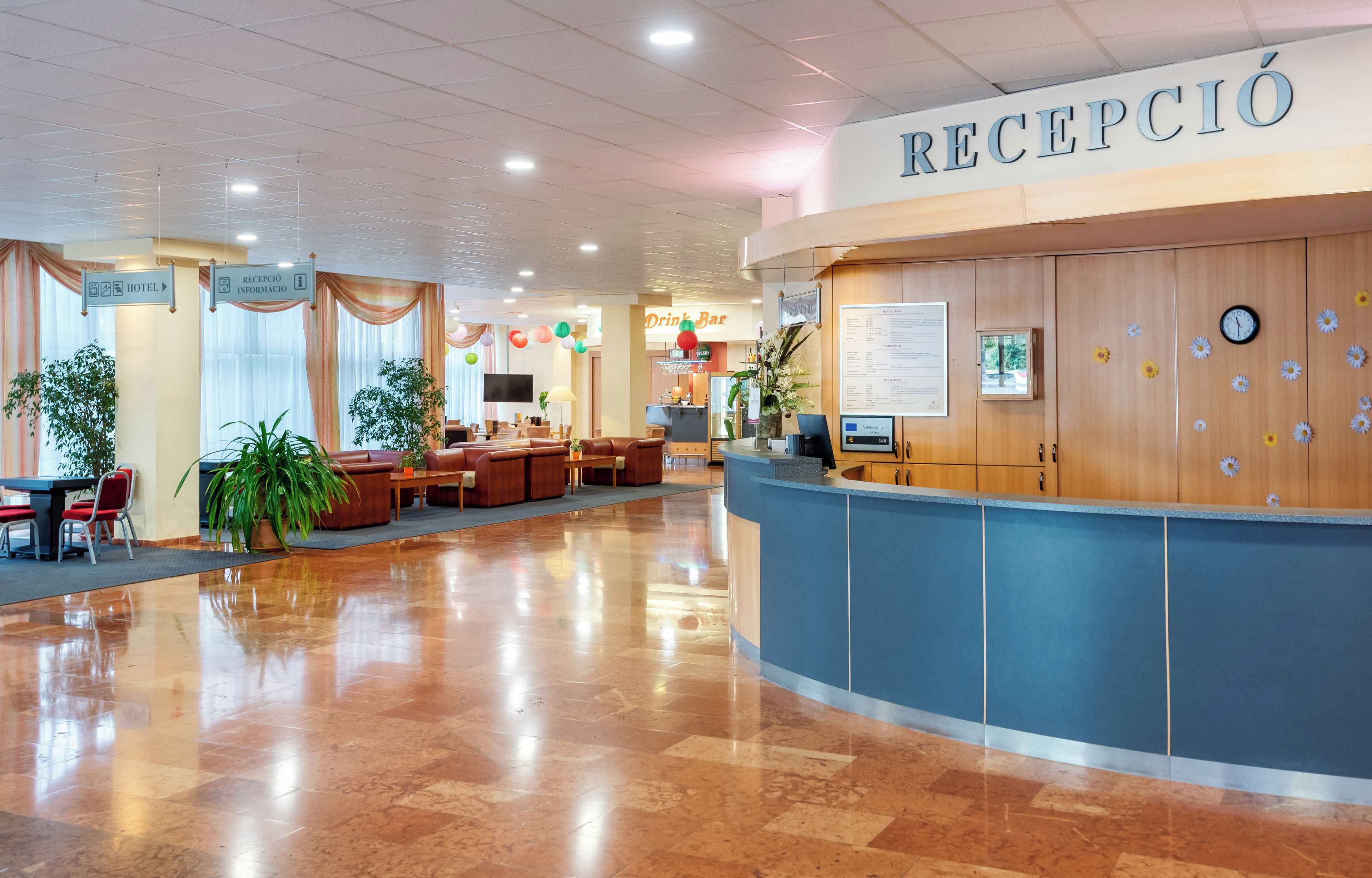 Een hotel receptie met een blauw aanrecht, een klok en een bord met de tekst 'RECEPCIÓN'.