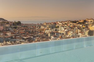 A cityscape with a view of a large body of water, buildings, and a distant mountain range.