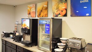 A self-service breakfast area with a coffee machine, a refrigerator, and a toaster.