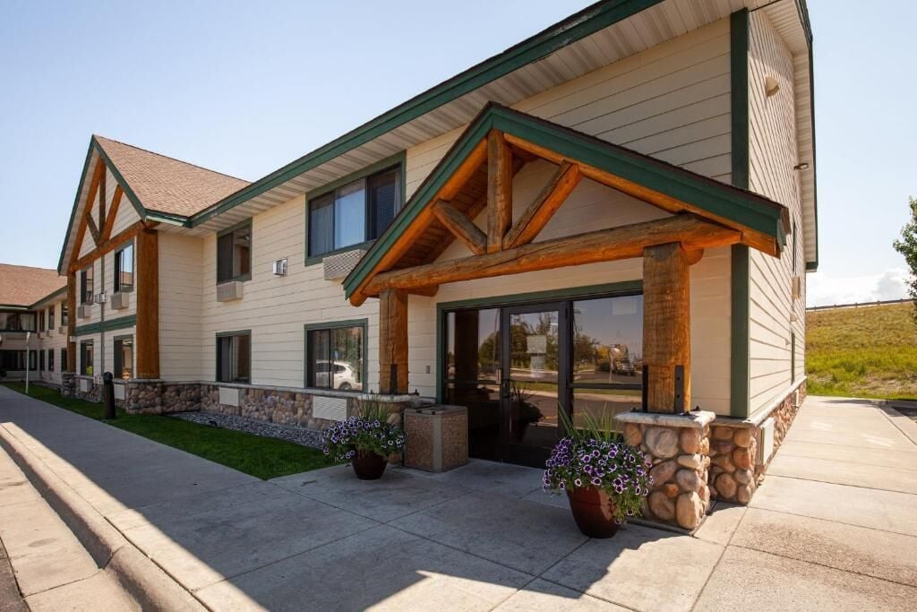 A two-story building with a covered entrance, stone accents, and a landscaped front yard.