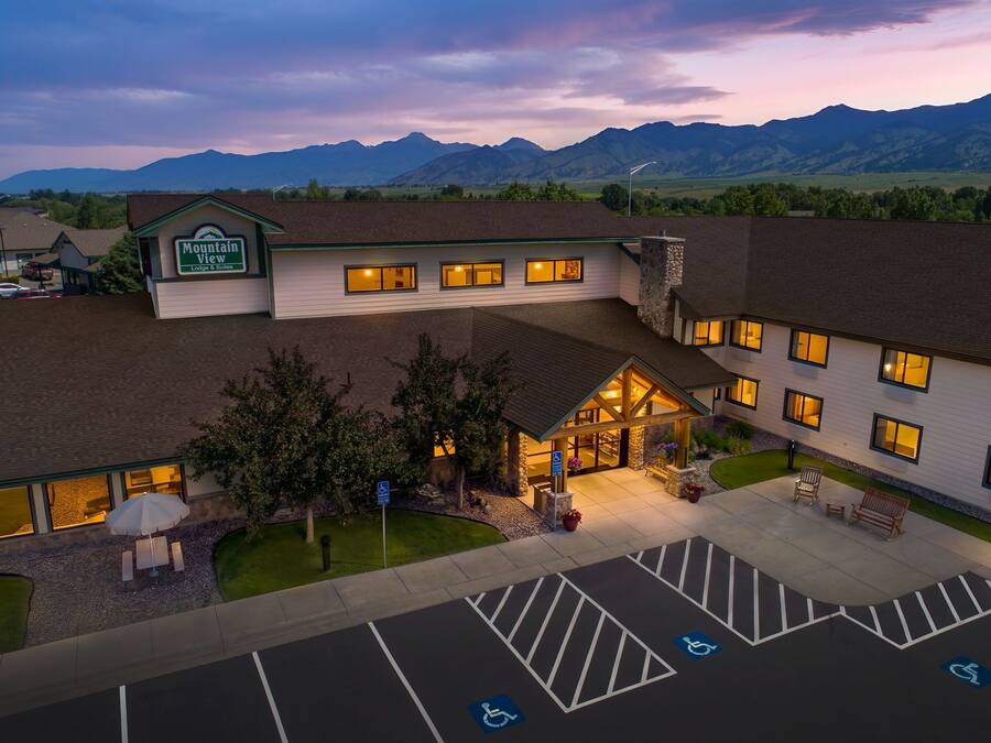 A hotel with a sign 'Mountain View Lodge & Suites' and a parking lot with handicapped parking spaces.