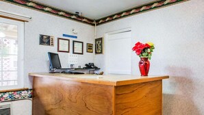 A reception desk with a computer, phone, and certificates on the wall.