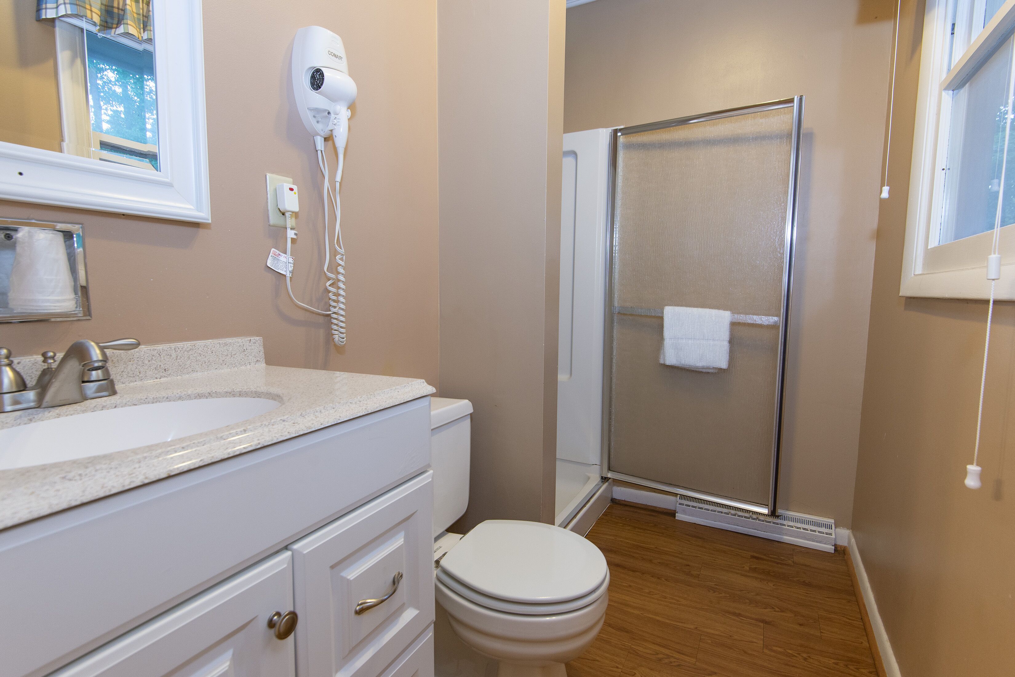 A bathroom with a sink, toilet, and a glass shower enclosure.