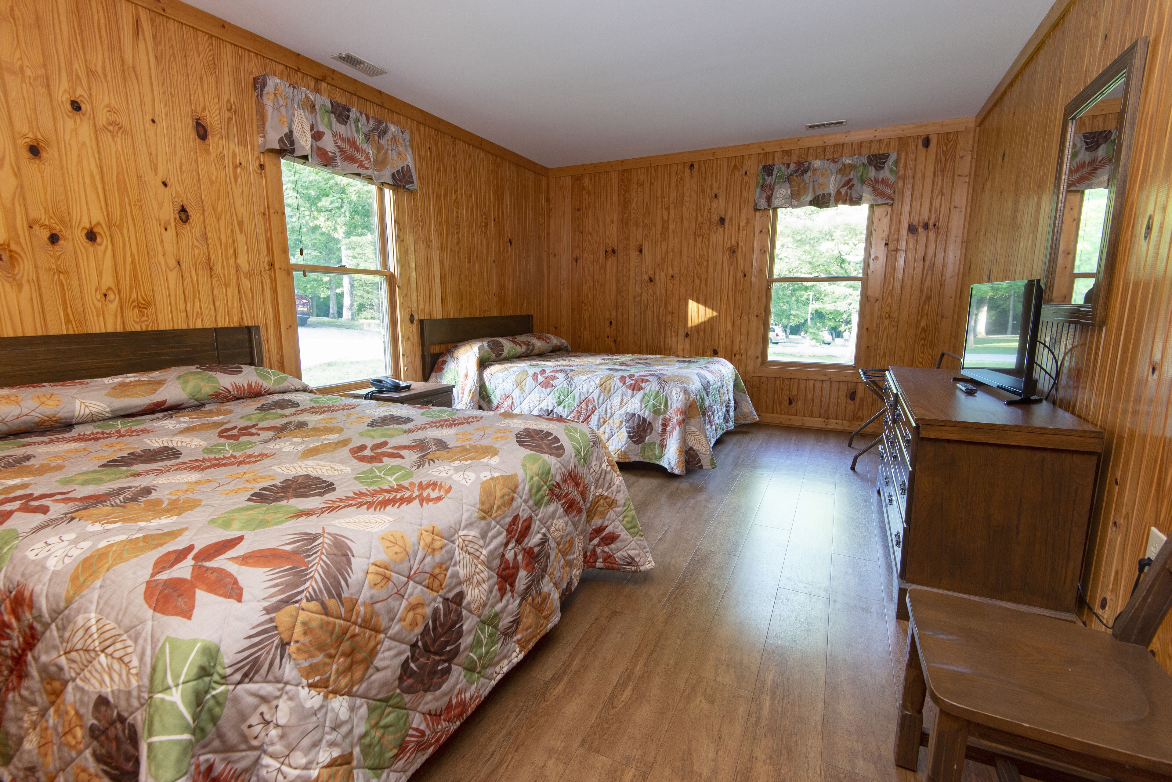 Une chambre avec deux lits, un bureau et une chaise.
