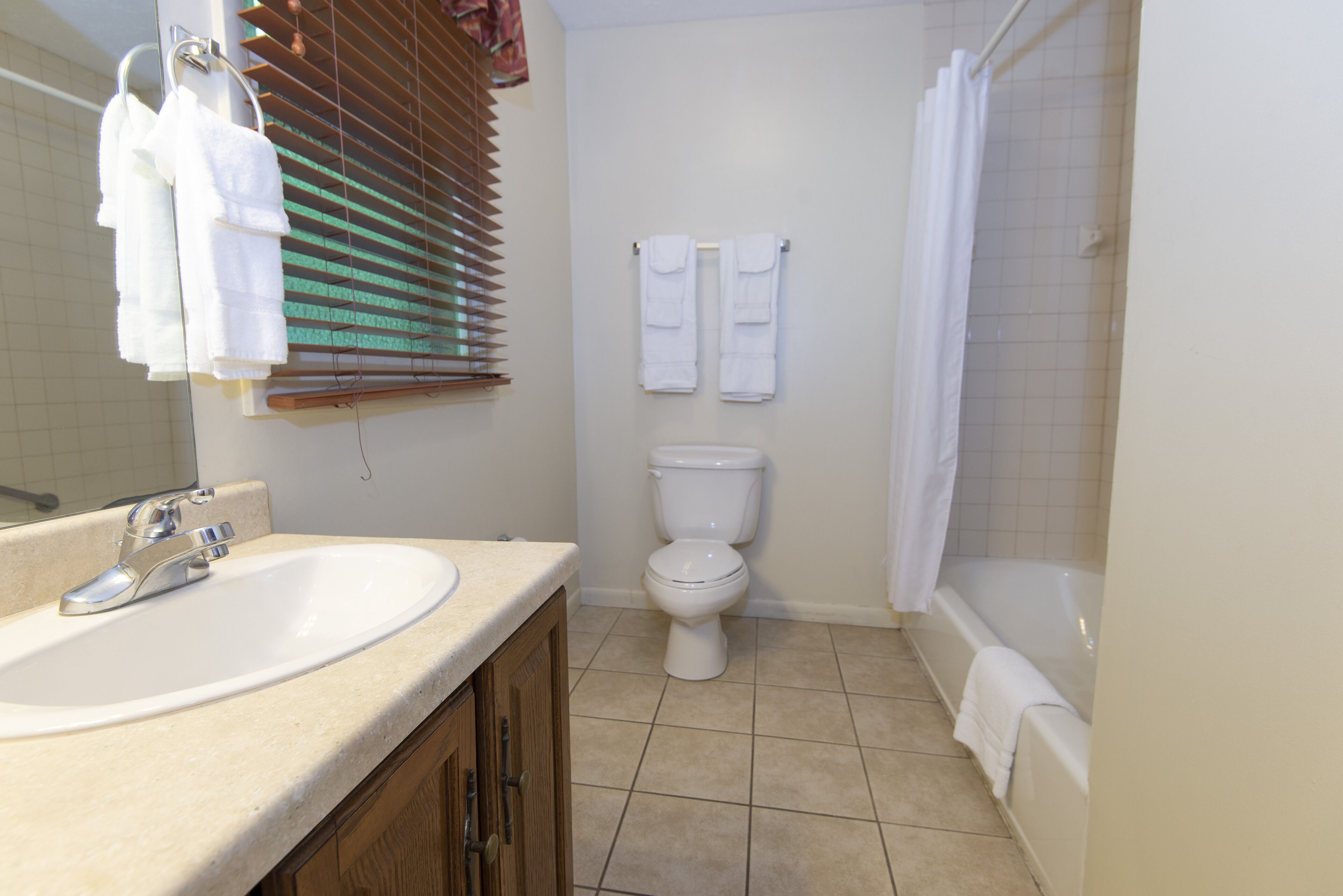 A bathroom with a sink, toilet, and bathtub.