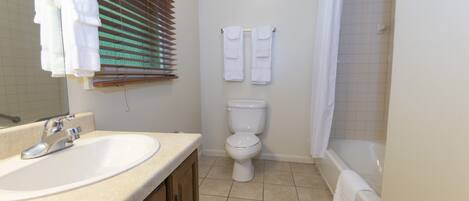 A bathroom with a sink, toilet, and bathtub.