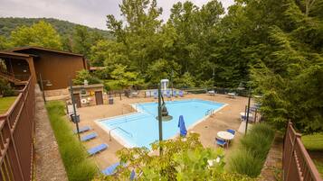 Relax by the serene pool surrounded by lush greenery and comfortable lounge seating.