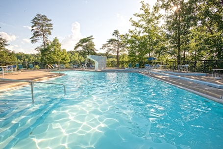 Una piscina al aire libre, sillones reclinables de piscina