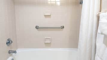 A bathroom with a bathtub, a toilet, and a shower curtain.