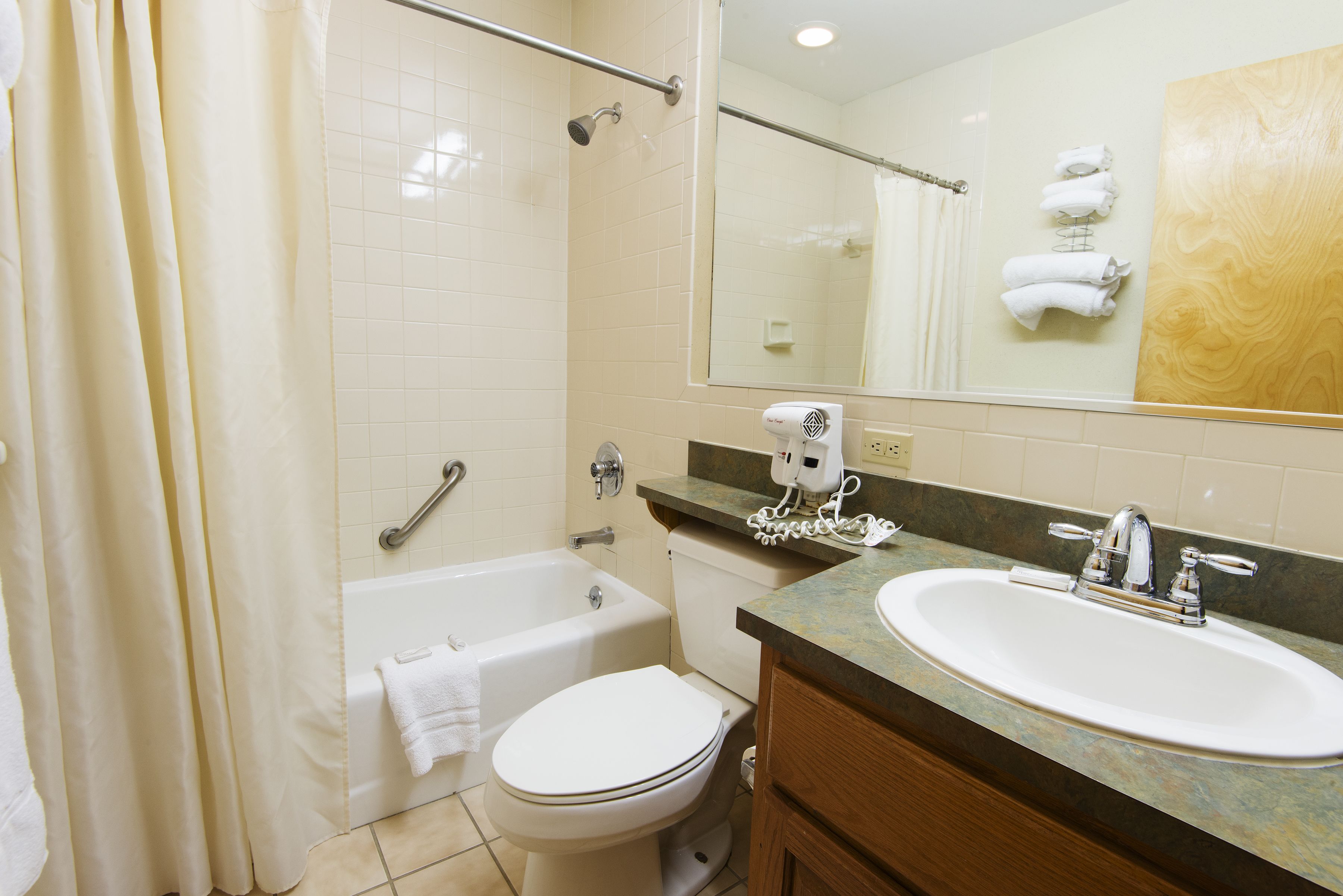 A bathroom with a bathtub, toilet, and sink.