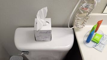 Toilette mit einer Tissuebox mit dem Aufdruck 'Enviro' und einem Tissue-Spender mit blauem und grünem Handdesinfektionsmittel.