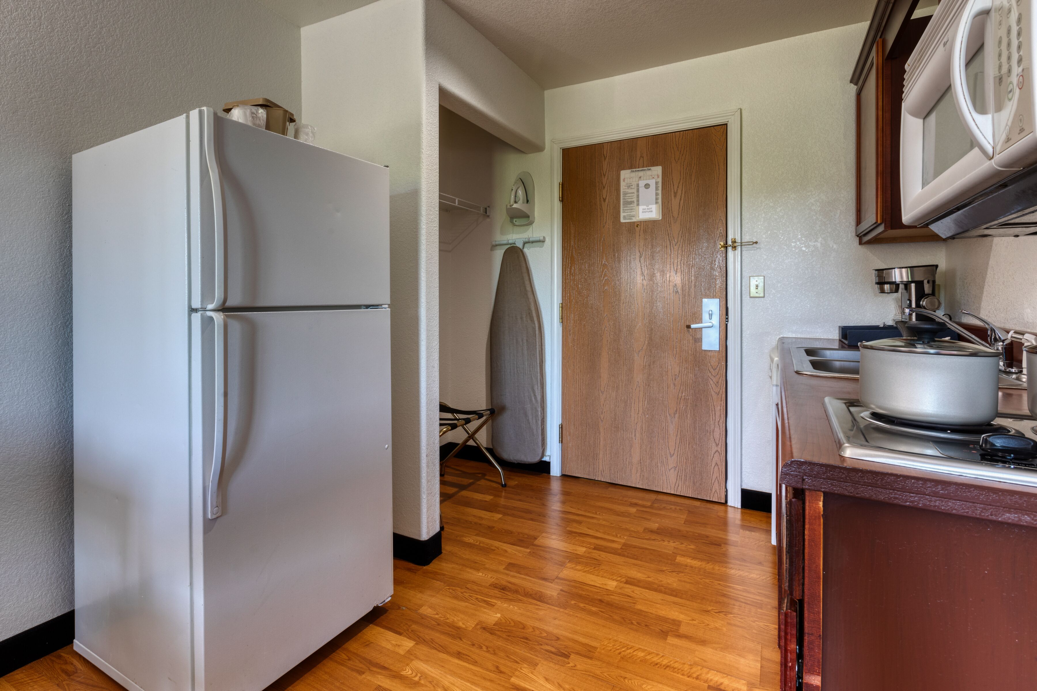 Una cocina equipada con refrigerador, estufa y microondas.