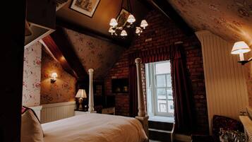 Un dormitorio con cama con dosel, una ventana con cortinas, una pared de ladrillo y un candelabro.