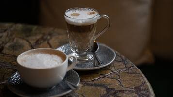 A cup of coffee with a saucer and a spoon on a table with a textured surface.