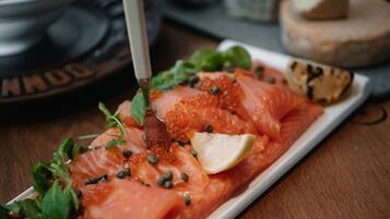 A plate of smoked salmon garnished with capers and a lemon wedge.