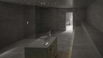 A modern bathroom with a large mirror, a sink, and a shower area.