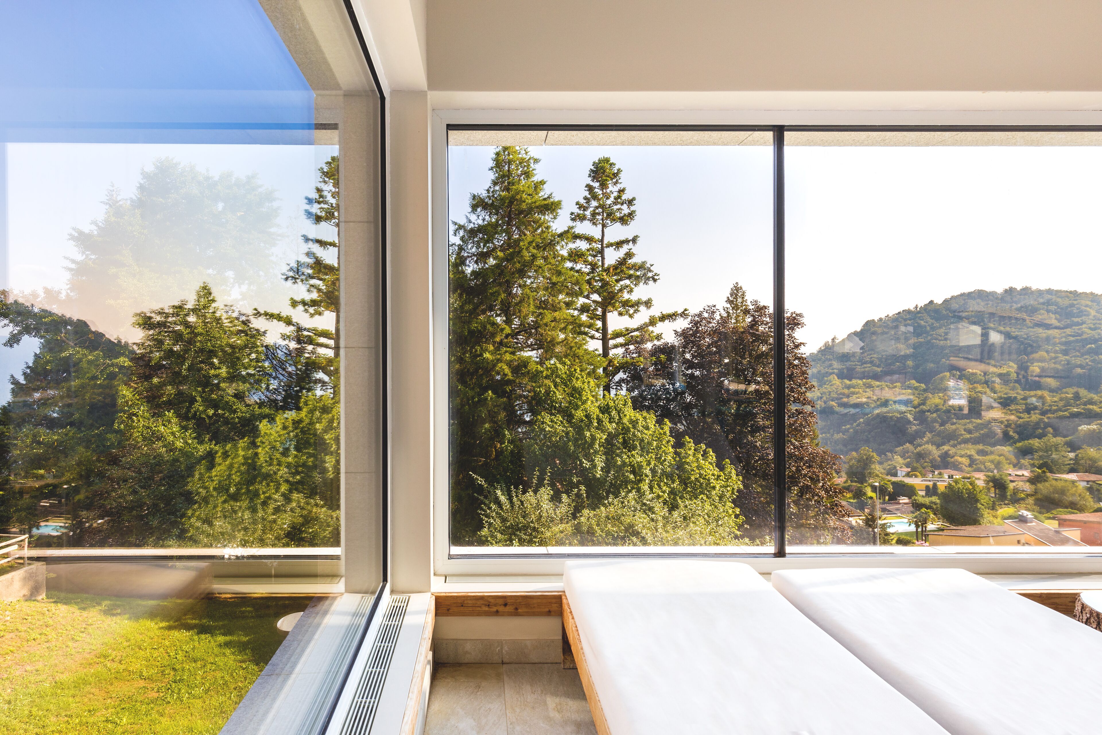 A modern room with large windows offering a view of trees and hills.