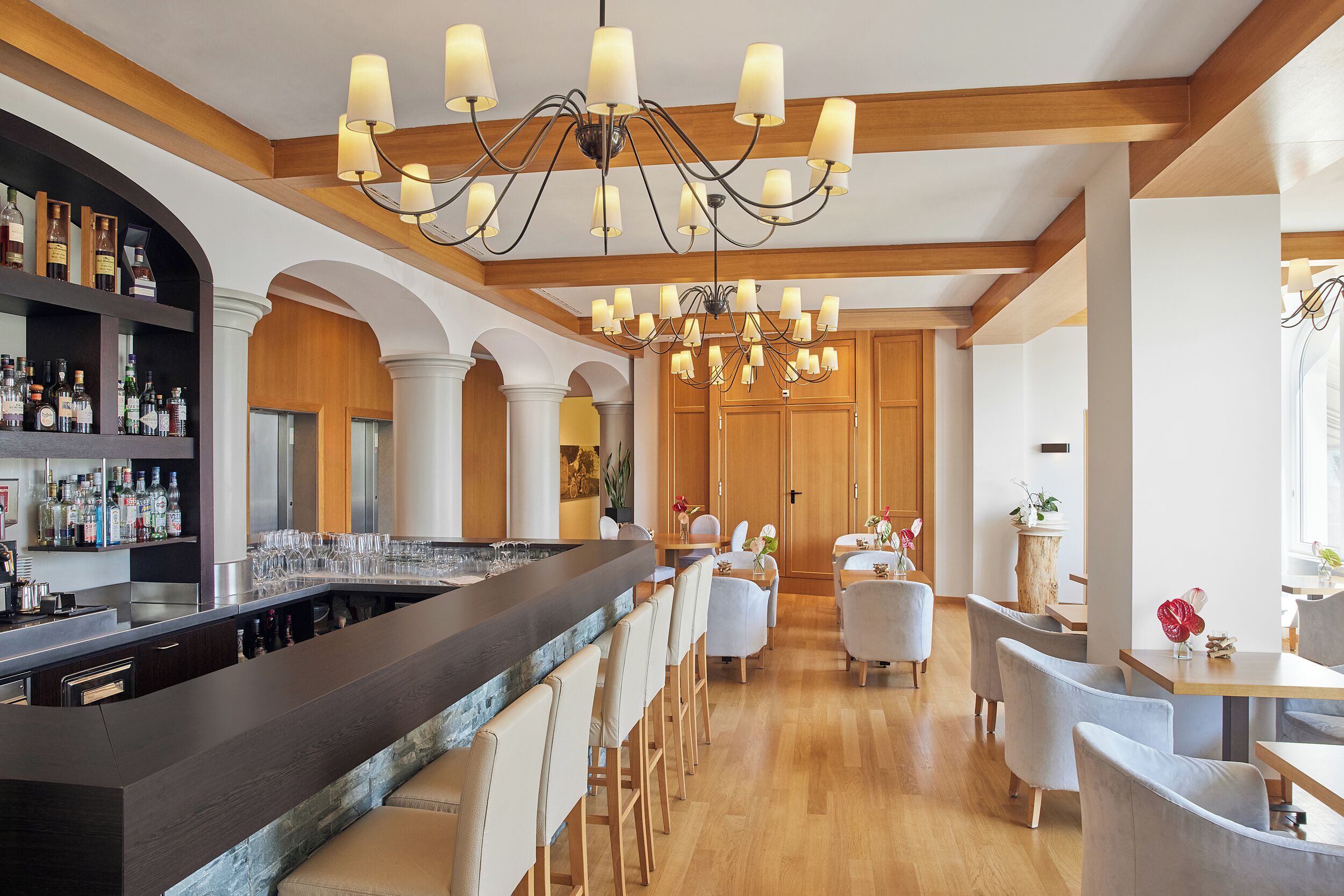A bar area with a long counter and multiple seating options.