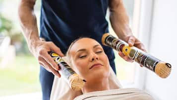 Une personne qui reçoit un massage, une serviette enroulée autour de son cou.