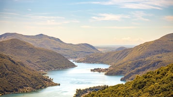Eine bergige Landschaft mit einem See und bewaldeten Hügeln.