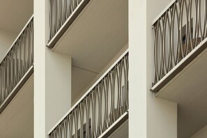 A modern building with balconies featuring geometric metal railings.