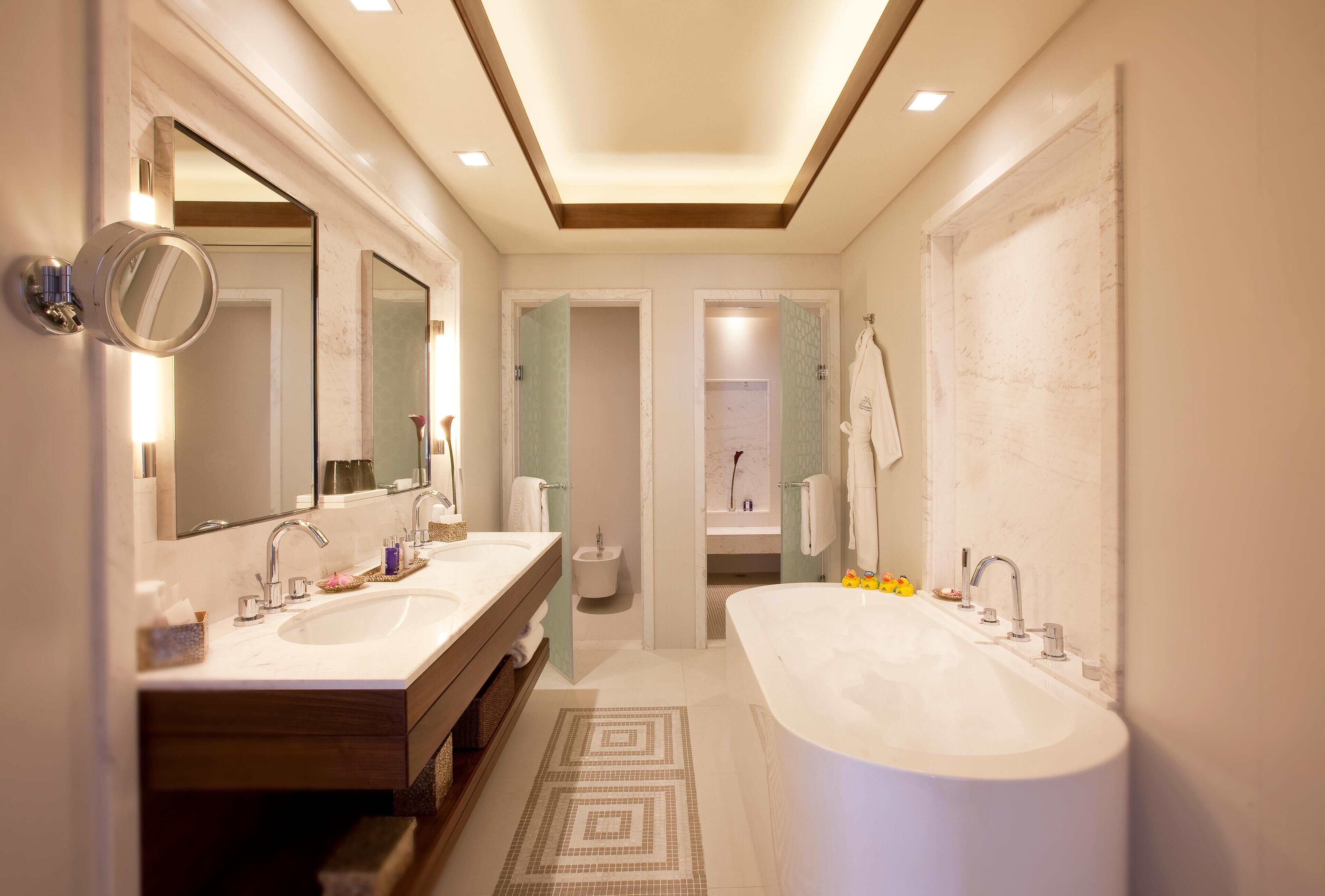 Une salle de bain moderne avec deux lavabos, une grande baignoire et une douche à l’italienne.