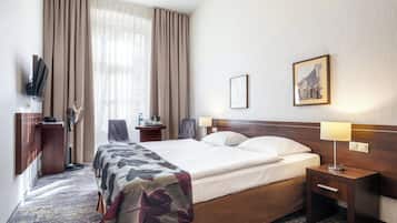 خزنة داخل الغرفة ومكتب ومكواة/لوح كي وملاءات أسرّة