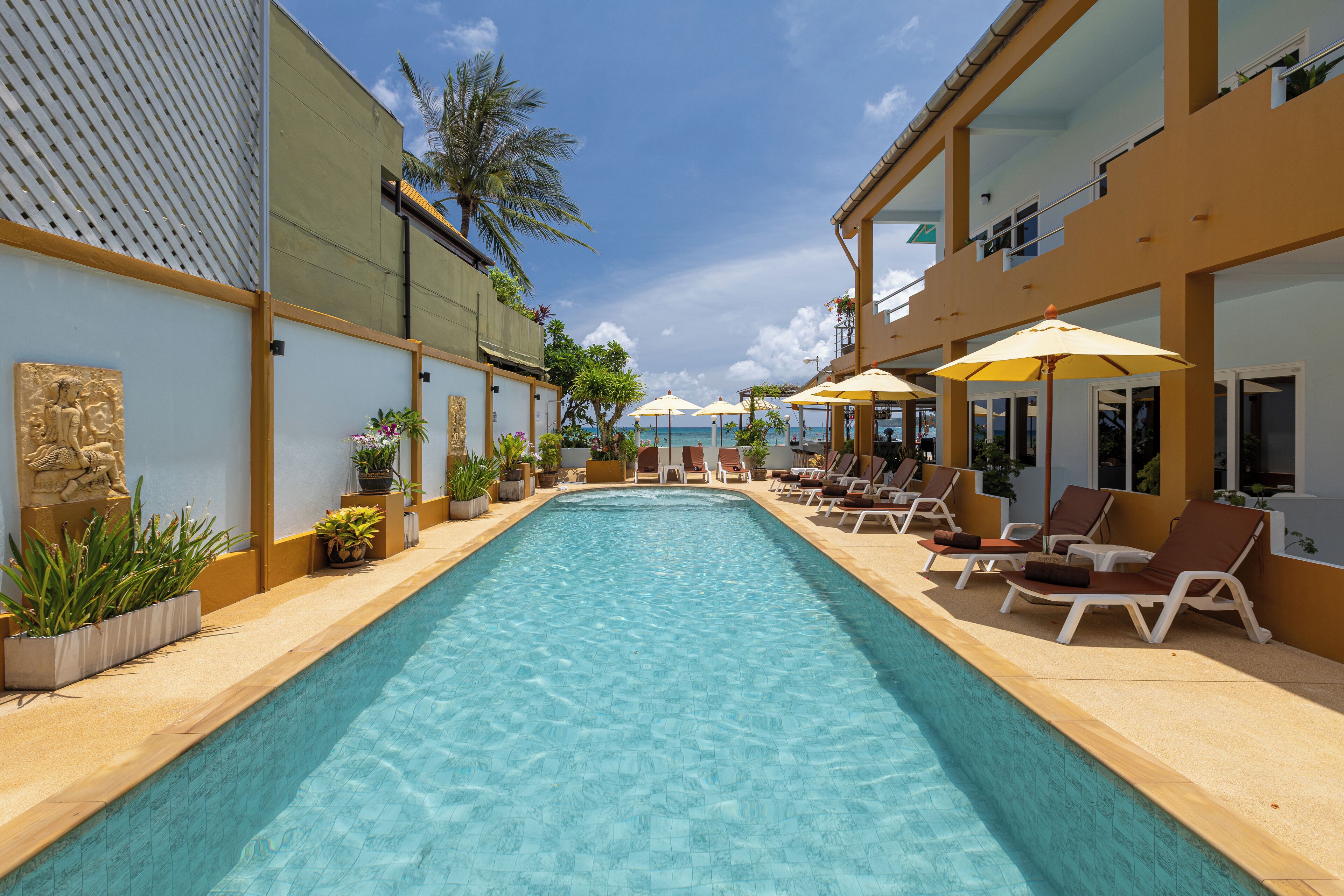 Una piscina al aire libre, sombrillas, sillones reclinables de piscina