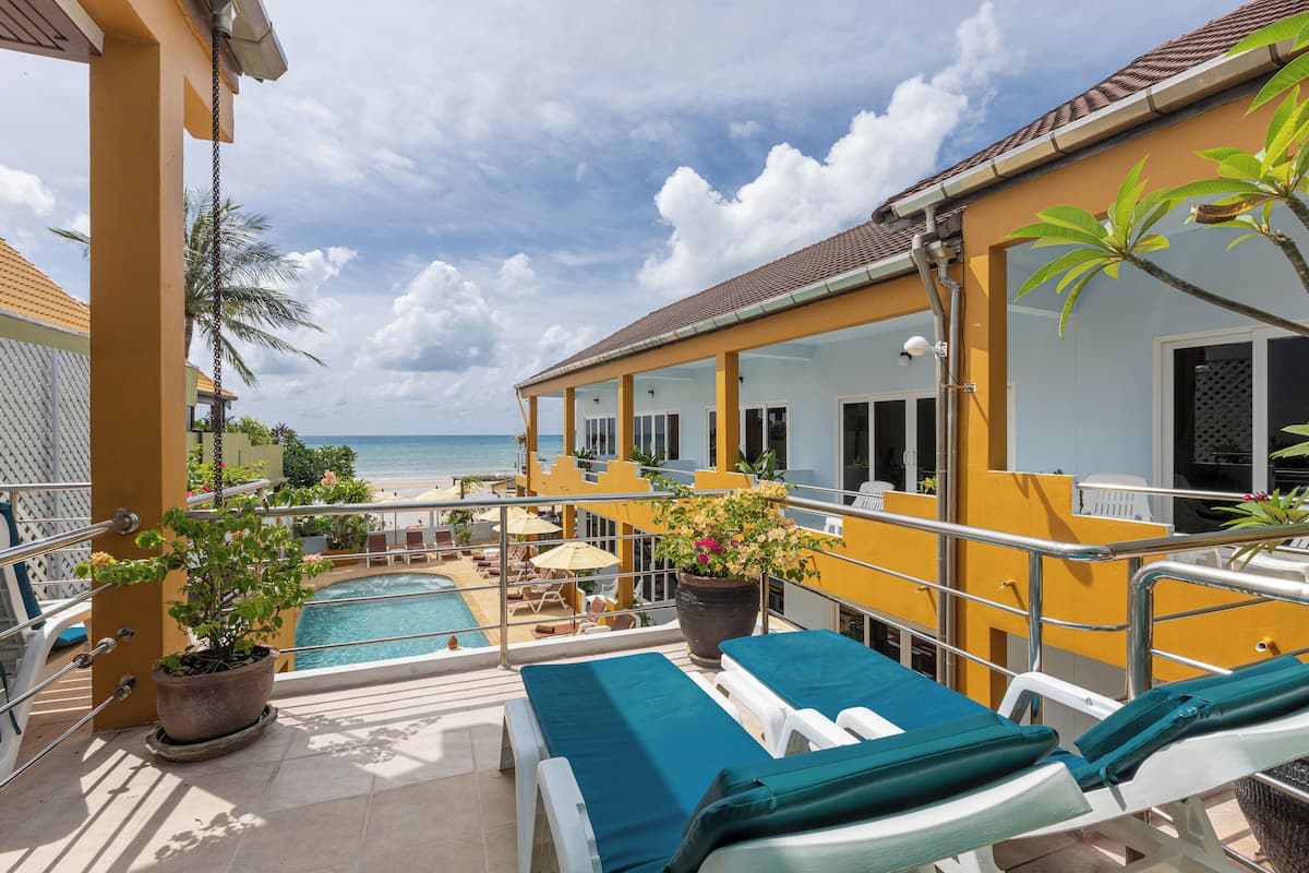 A poolside area with lounge chairs and a view of the ocean.