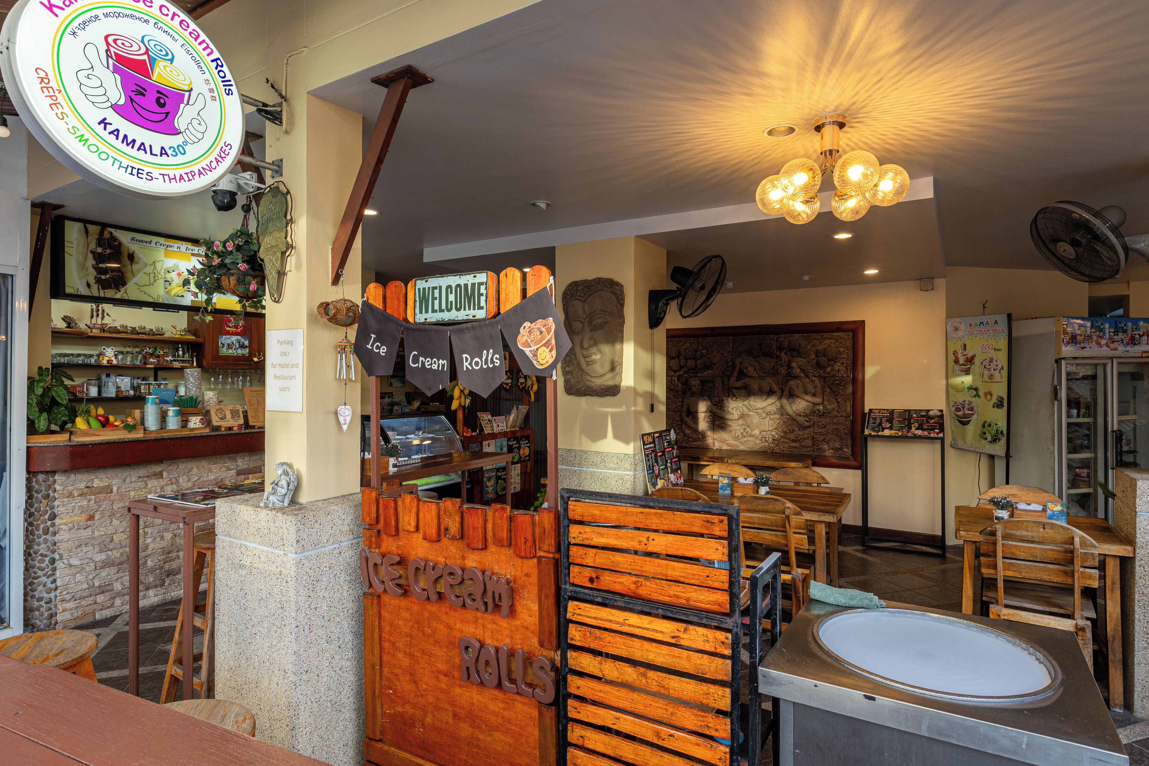 A restaurant interior with a counter, wooden furniture, and a sign indicating 'Cream Rolls' and 'Ice Cream Rolls'.