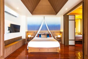 A spacious bedroom with a large bed, a television on the wall, and a wooden ceiling.