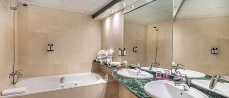 A modern bathroom with a bathtub, two sinks, and a large mirror.